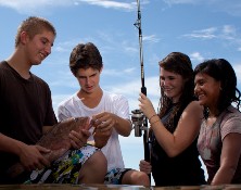 group of diverse teens inspecting a fish they just caught