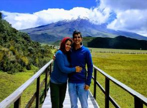 A couple poses in front of a mountain